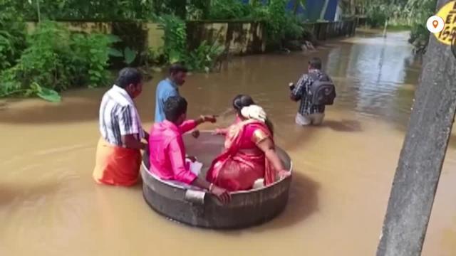 عروسان هنديان يستقلان إناء طهي عملاقا إلى موقع زفافهما بسبب الفيضانات